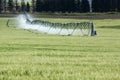 An agricultural center pivot irrigation sprinkler in a barley field