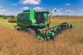 agricultural field during harvest time with industrial combine machine in the working process Royalty Free Stock Photo