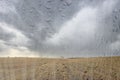 Agricultural field after rain with clouds in the sky behind wet glass in golden autumn. Bad weather concept. Abstract landscape