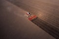 Agricultural industrial tractor plows soil field for sowing , aerial top view. Land cultivation, spring farming concept