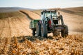 Agricultural industy - Industrial Tractor with trailer working the corn fields and harvesting during fall season