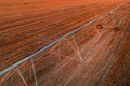 Agricultural irrigation line with lateral move in harvested rapeseed field, aerial shot from drone pov