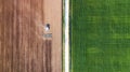 Agricultural landscape from air. Farm machine on the field. Harvesting on the field. Road through the field. Top view from flying