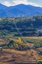 agricultural landscape with mountainous background with light cables going up to the mountain