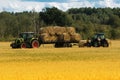 Agricultural loader loads stacks of hay to transport on the farm