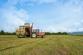 Agricultural scene. Tractor lifting hay bale on barrow. Royalty Free Stock Photo