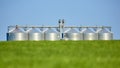 Agricultural Silos - Building Exterior, Storage and drying of grains, wheat, corn, soy, sunflower against the blue sky with wheat Royalty Free Stock Photo