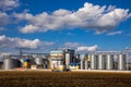 Agricultural Silos. Storage and drying of grains, wheat, corn, soy, sunflower against the blue sky with white clouds.Storage of Royalty Free Stock Photo