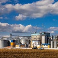 Agricultural Silos. Storage and drying of grains, wheat, corn, soy, sunflower against the blue sky with white clouds.Storage of Royalty Free Stock Photo