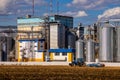 Agricultural Silos. Storage and drying of grains, wheat, corn, soy, sunflower against the blue sky with white clouds.Storage of Royalty Free Stock Photo