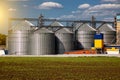 Agricultural Silos. Storage and drying of grains, wheat, corn, soy, sunflower against the blue sky with white clouds.Storage of Royalty Free Stock Photo