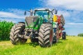 Agricultural summer bright landscape. Large seeder near corn field against a background of clouds