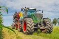 Agricultural summer bright landscape. Large seeder near corn field against a background of clouds