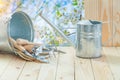 Agricultural tools bucket with handtools and watering can on table in spring garden Royalty Free Stock Photo