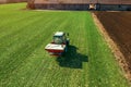 Agricultural tractor fertilizing wheat crop field with NPK Royalty Free Stock Photo