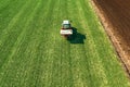 Agricultural tractor fertilizing wheat crop field with NPK Royalty Free Stock Photo