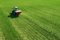 Agricultural tractor fertilizing wheat crop field with NPK Royalty Free Stock Photo