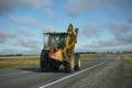 Agricultural Tractor rides on the asphalt country road, grass mower