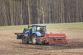 Agricultural tractor with seeder in the field, spring day Royalty Free Stock Photo