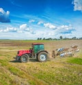 Agricultural view tractor with plough standing on field