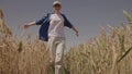 agriculture, happy agronomist runs across the field with raised hands, farmer works in the countryside, ears of wheat on Royalty Free Stock Photo