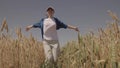 agriculture, happy agronomist runs across the field with raised hands, farmer works in the countryside, ears of wheat on Royalty Free Stock Photo