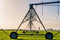 Agriculture modern irrigation. watering spray machine set on the green grassland field with blue sky and warm light scene. I