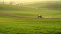 Agriculture on Moravia rolling hills with wheat filds and tractor Royalty Free Stock Photo