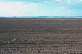 Agriculture plowed field. Black soil plowed field. Tillage soil prepared for planting crop. Fertile soil in organic agricultural