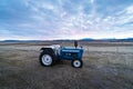 Agriculture stock picture. A small tractor on a field during the sunset time. Agriculture in Iceland, Scandinavia Royalty Free Stock Photo