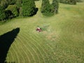 Tractor finish cut hay grass on field and white storks, aerial view Royalty Free Stock Photo