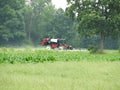 Agriculture tractor spreading liquid fertilizer on newly planted crop field Royalty Free Stock Photo