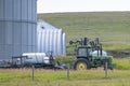 An agriculture tractor towing a pesticide container at a farm