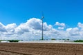 Agriculture and wind power with asparagus field and greenhouses.