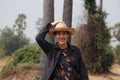 Agriculturist male catch his hat and standing on nature