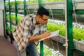 Agriculturist writing notes while working in greenhouse