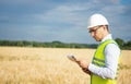 Agro engineer at the field inspection, the farmer stands in a wheat field with a folder in his hands and checks the harvest, the Royalty Free Stock Photo