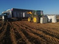 Agro tractor loading potatoes in a harvest