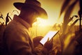 Agronomist farmer man using digital tablet computer in a young cornfield at sunset or sunrise Royalty Free Stock Photo