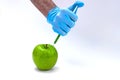 Syringe injection into a apple with sorbic acid waiting for long-term storage of fruit. Genetic modified foods. isolated on white