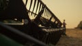 Agronomist silhouette rest wheat farmland lean harvester machine golden sunset.