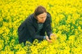 Agronomist woman examining oilseed flower blooming Royalty Free Stock Photo