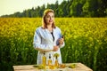 Agronomist woman or farmer examine rapeseed oil using tablet on the background of  blossoming rape canola field Royalty Free Stock Photo