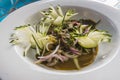 Aguachile de trout, typical Mexican food, garnished with cucumber, purple onion, bathed in serrano chili sauce and chiltepin