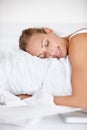 Ah, so soft. A beautiful young woman hugging her pillow while on her bed. Royalty Free Stock Photo