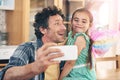 Ah, youve done this selfie thing before. a happy father and daughter taking a selfie together on a mobile phone at home. Royalty Free Stock Photo