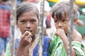 Ahemdabad, Gujarat, India - 20th june, 2019: Poor indian helpless street girl holding little kid in hand looks at camera, seeking