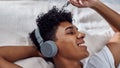 Ahh music....you just know how. a young man using headphones to listen to music at home.