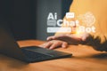 AI chatbot concept showing a person using a laptop with virtual chat icons, symbolizing artificial intelligence communication Royalty Free Stock Photo