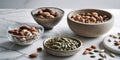 Assorted Nuts and Seeds Displayed in Rustic Bowls on Marble Surface. Royalty Free Stock Photo